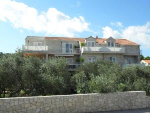 a large house on top of a hill with trees at Apartments Zeljko in Lumbarda