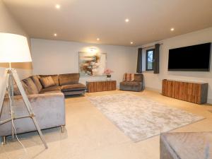 a living room with a couch and a flat screen tv at Farley Meadow View in Matlock