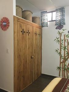1 dormitorio con armario de madera en una habitación en CASITA MADAME, en Puerto López