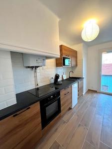 a kitchen with a black counter top and wooden floors at Agréable T2 cosy - centre-ville in Perpignan