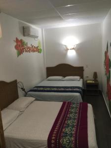 una habitación de hotel con 2 camas en una habitación en CASITA MADAME, en Puerto López