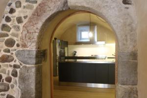an archway leading into a kitchen with a stone wall at Agriturismo La Ciasa Del Fabio in Tassullo +54 photos
