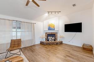 a living room with a fireplace and a flat screen tv at Happy Daze Home in Buda