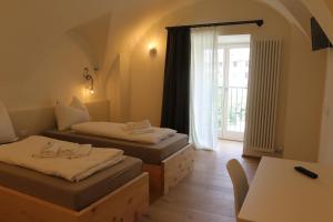 a room with two beds and a table and a window at Agriturismo La Ciasa Del Fabio in Tassullo