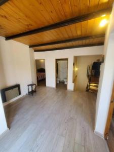una sala de estar vacía con techo de madera y suelo de madera en Departamento céntrico amplio con garage automatizado 24 Hs en Santa Rosa