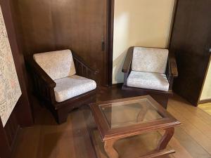 two chairs and a coffee table in a room at Suites Aconchego do Centro - Localizado no Centro in Canela
