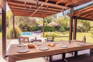 una mesa con platos y copas de vino en un patio en Casa Shanti - La Barra, en Punta del Este