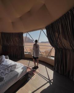 a person standing in a room with a window at Wadi Rum Rose camp in Wadi Rum