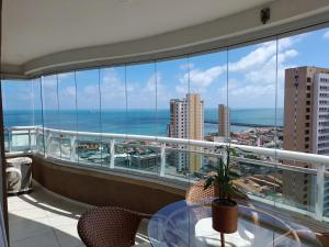 d'un balcon avec une table et une vue sur l'océan. dans l'établissement Studio Iracema 2001, à Fortaleza