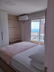 - une chambre avec un grand lit et une grande fenêtre dans l'établissement Studio Iracema 2001, à Fortaleza