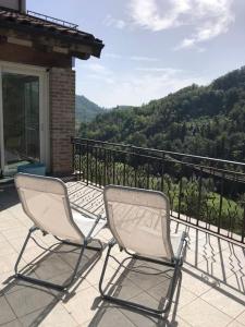 - deux chaises assises sur un balcon avec vue sur la montagne dans l'établissement Ca' Cuore in Monferrato, à Serralunga di Crea