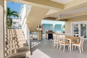 a patio with a table and chairs and a staircase at Fantastic Fifth Street in Key Colony Beach