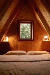 Cama en habitación con ventana en Sítio CRIA - Hospedagem Sustentável & Experiências Rurais, en Três Coroas