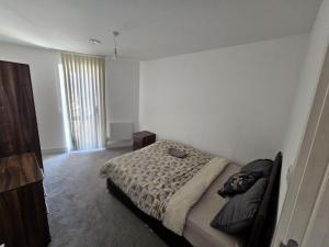 a bedroom with a bed and a large window at Hippersley Point, Tilston Bright Square, Abbey Wood, London SE2 9DR, UK in London