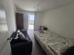 a bedroom with a bed and a chair in it at Hippersley Point, Tilston Bright Square, Abbey Wood, London SE2 9DR, UK in London