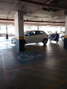 a car parked in a parking lot with a scooter at Quarto com acabamento superior no Design Hotel Linhares in Linhares