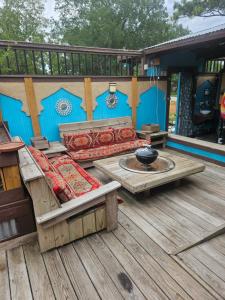 a wooden deck with a couch and a fire pit at RestStop Hostel in Houston