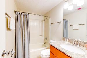 un baño con lavabo e inodoro en Hibernation Hideaway, en McHenry 24 fotos más