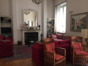 sala de estar con sofá rojo y chimenea en Il Giardino Nascosto, en Busto Arsizio