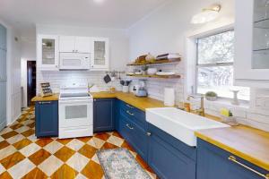 cocina con armarios azules y fregadero blanco en Blue Haus, en Johnson City