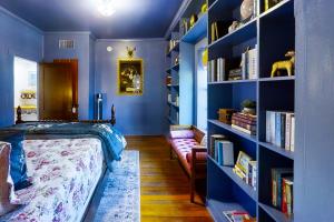 1 dormitorio con paredes azules, 1 cama y estanterías en Blue Haus, en Johnson City