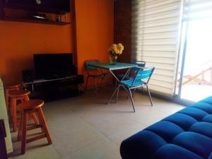 salon z niebieską kanapą, stołem i krzesłami w obiekcie Hermoso Apto. frente a Playa Salguero - Santa Marta w mieście Puerto de Gaira