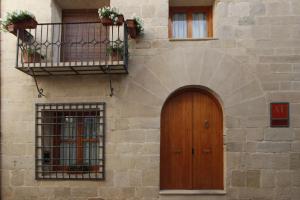 een gebouw met een houten deur en een balkon bij Casa 1340 in Mora de Rubielos
