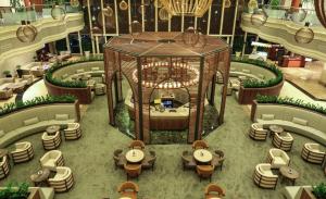 una vista panoramica su una hall dell'hotel con tavoli e sedie di Adana HiltonSA Hotel a Adana