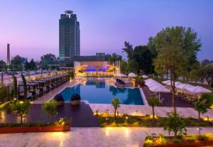 uma vista panorâmica de uma piscina do hotel à noite em Adana HiltonSA Hotel em Adana