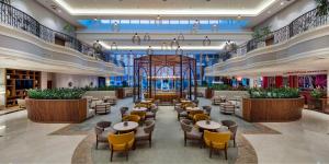 ein Restaurant mit Tischen und Stühlen in der Lobby in der Unterkunft Adana HiltonSA Hotel in Adana