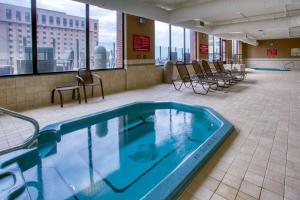 a swimming pool in a building with chairs and windows at Drury Plaza St. Louis at the Arch in Saint Louis