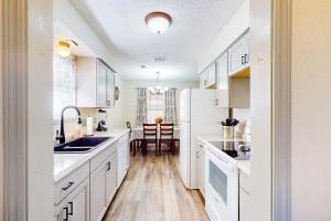 a kitchen with white cabinets and a sink at Casa de Cowboy in Stillwater