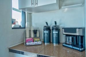 a kitchen counter with two thermoats and a coffee maker at Motel 6 Tucson, AZ - East Williams Center in Tucson