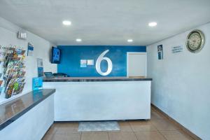 a counter in a store with a clock on the wall at Motel 6 Tucson, AZ - East Williams Center in Tucson +33 photos