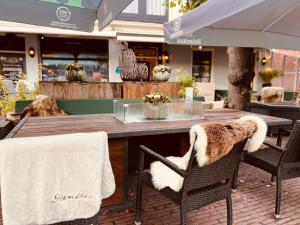 una mesa de madera con 2 sillas y toallas. en Hotel Onder De Linden, en Roden