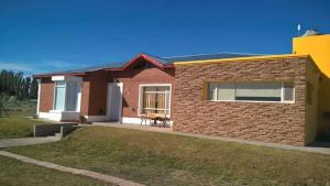 una piccola casa di mattoni con un prato di fronte di Muy Patagónica, Casa de Campo a Trelew