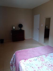 a bedroom with a bed and a dresser and a mirror at Apê perto do Parque Euclides Dourado in Garanhuns