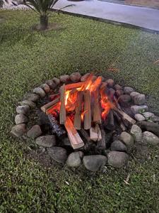 a fire pit with logs and rocks in the grass at Bahan Pousada - Pousada em Ubatuba in Ubatuba