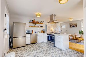 kuchnia z białymi szafkami i lodówką ze stali nierdzewnej w obiekcie Serene Cottage w mieście Charleston +6 zdjęć