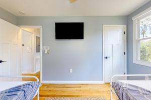 - une chambre avec 2 lits et une télévision murale à écran plat dans l'établissement Serene Cottage, à Charleston