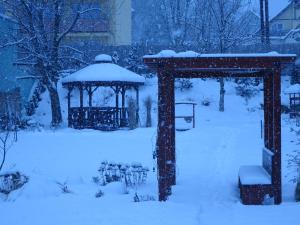 un cenador en un patio cubierto de nieve en family friendly apartment 3 adults plus child en Ružomberok
