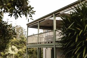 a house with a balcony on the side of it at Hey Little Joe - Cosy Retreat with Mountain Views in Warburton
