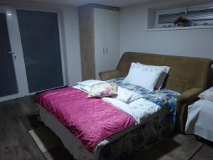 Cama en habitación con manta morada en family friendly apartment 3 adults plus child en Ružomberok