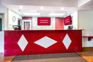 un comptoir rouge avec un panneau indiquant une connexion Wi-Fi gratuite à l'avant dans l'établissement Red Roof Inn Palatine, à Palatine