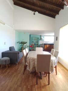 una sala da pranzo con tavolo, sedie e divano di Muy Patagónica, Casa de Campo a Trelew