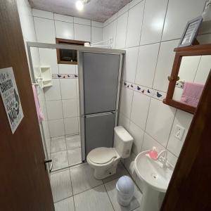 a small bathroom with a toilet and a sink at Rosatrip Surf Bungalows in Praia do Rosa