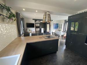 a kitchen with black cabinets and a counter top at Maison avec piscine, sauna, spa in Cepoy