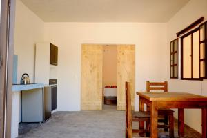 a kitchen with a table and a door to a room at Superbe appartement avec chambre, piscine et parking privé in El Pescadero