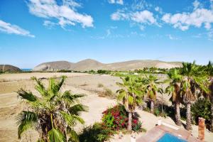 uma vista aérea de uma praia com palmeiras e uma piscina em Superbe appartement avec chambre, piscine et parking privé em El Pescadero