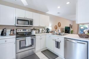 a kitchen with white cabinets and a stove top oven at Tranquil Townhome in Auburn